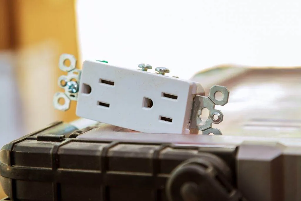 a white electrical outlet on a black surface